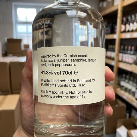 Back label of the gin bottle, held in a hand